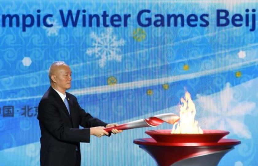 Tajemník pekingského městského stranického výboru a předseda organizačního výboru zimních olympijských her Cai Qi zapaluje olympijský oheň.