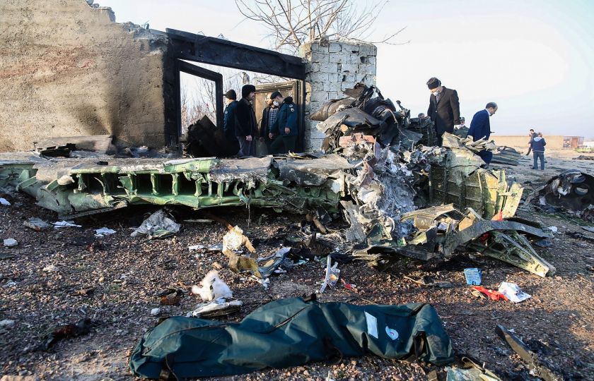 Lidé stojí u trosek ukrajinského letadla poblíž letiště v Teheránu, které se zřítilo 8. ledna. Všech 176 lidí na palubě zemřelo. Foto: Profimedia.