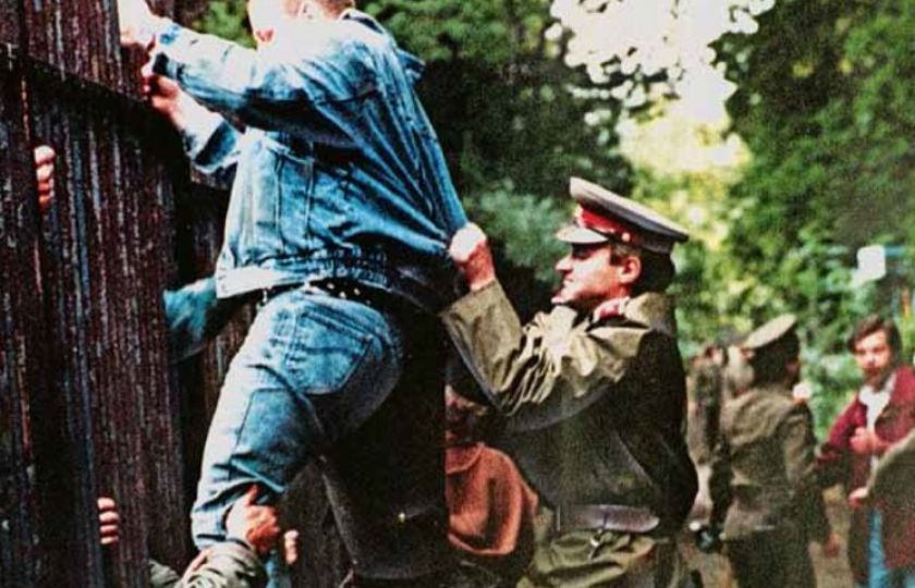 Československý policista se pokouší zabránit jednomu z uprchlíků z NDR přelézt přes plot do zahrady tehdejšího západoněmecké velvyslanectví. Foto: archiv LtN