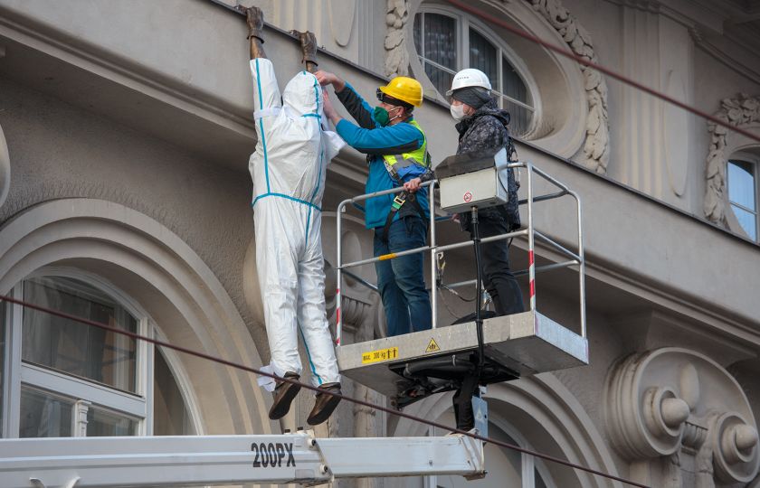 Oblékání sochy Lupiče do antikovidové kombinézy. Foto: MUO.