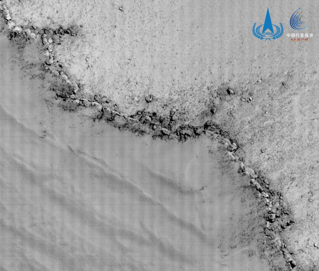 Snímek okraje prstencového kráteru Mond zachycený kamerou s vysokým prostorovým rozlišením. Levá spodní část obrázku ukazuje vnitřek prstencového kráteru, je zřetelně vidět, jak se jeho hrana propadá do prohlubně. Zdroj: Čínská Národní astronomická observatoř