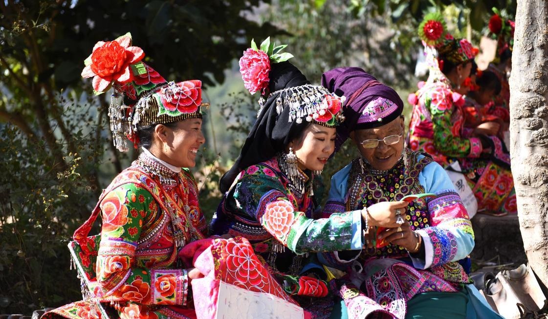 Ženy etnické menšiny Yi ve vesnici Bijiada v městečku Dacang v okresu Weishan v prefektuře Dali v provincii Yunnan šijí tradiční oděvy. Národní řemeslo se stalo novým průmyslovým odvětvím zmírňujícím chudobu. Foto Zhang Shulu / Guangming Picture. 